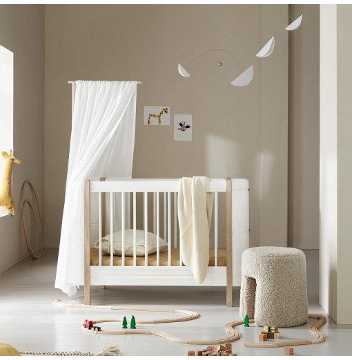 Elegante interior de la habitación del bebé recién nacido con cama colgando  con dosel blanco con cuna